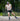 Iivo Niskanen roller skiing on a paved surface with greenery in a green background
