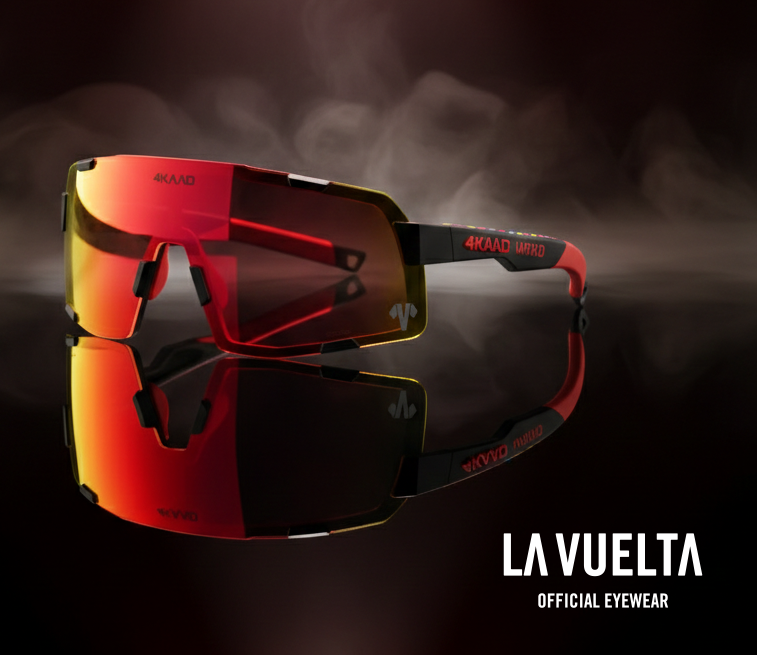 Sleek sports sunglasses with reflective red and yellow lenses are spotlighted against a smoky background. "La Vuelta Official Eyewear" is in bold text.