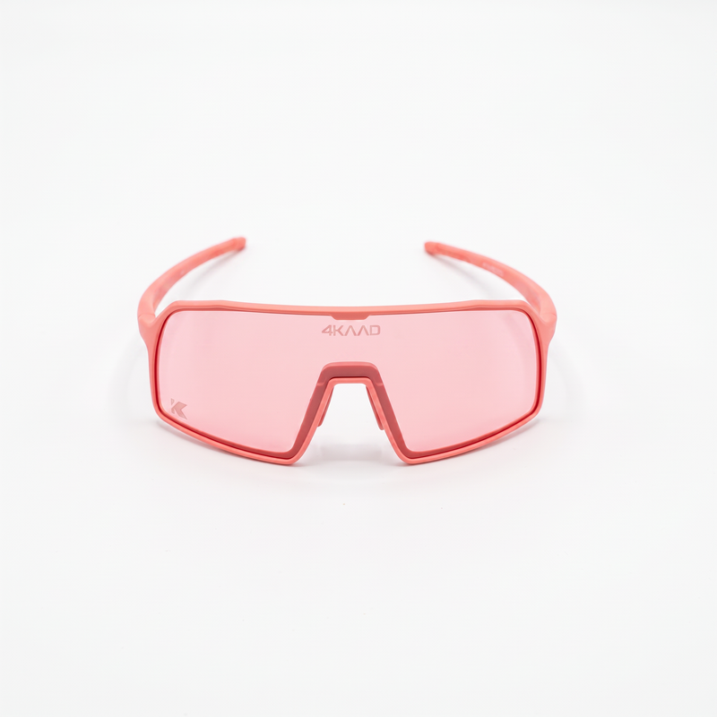 A pair of wraparound shield-style sunglasses with a translucent coral pink frame and matching pink lenses, shown on a clean white background. The brand name '4KVAR' is printed on the upper part of the lens.